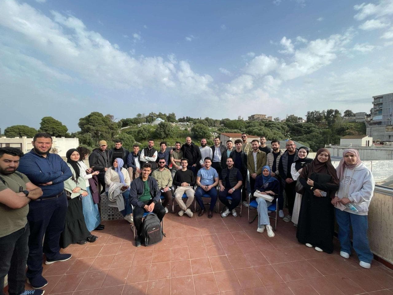 المشاركون في Agentic AI Hackathon، ومنهم شامل، مجتمعون على سطح مكتب Ayor تحت سماء زرقاء