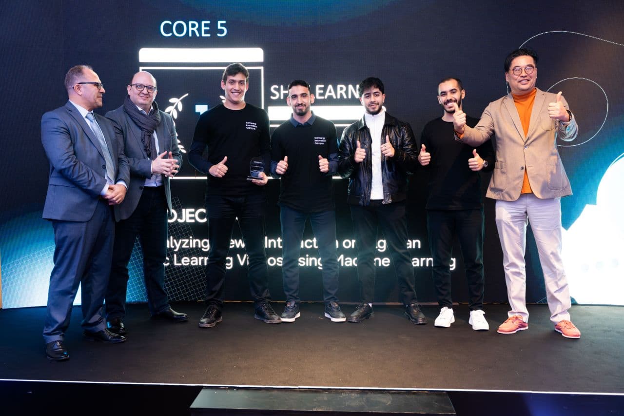 شامل يحمل جائزة المرتبة الأولى على المنصة مع فريق المشروع الختامي وممثلي Samsung Innovation Campus